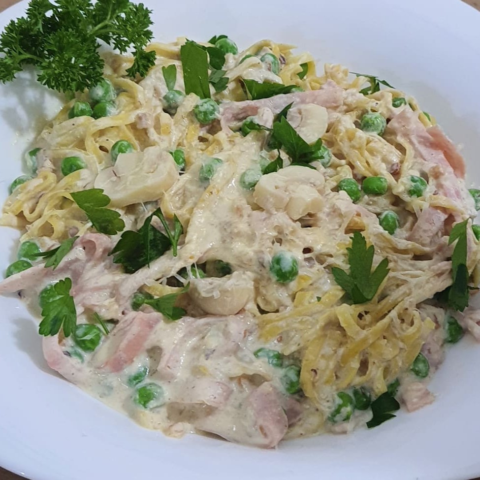 Delicioso espaguete artesanal, perfeitamente al dente, generosamente mesclado com fatias finas de presunto de textura suave. Acompanhado de champignons frescos e ervilhas tenras, todos envoltos em nosso exclusivo e cremoso molho de queijo parmesão. Este prato é uma verdadeira celebração de sabores autênticos e ricos, que remetem aos encantos da culinária italiana. Perfeito para os amantes de massas que buscam uma experiência gastronômica única e memorável.