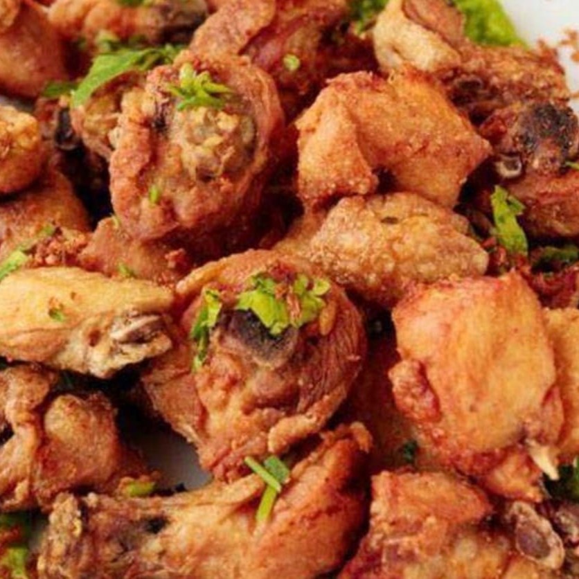 Cortes de coxa e sobrecoxa fritos, servidos com alho torrado.