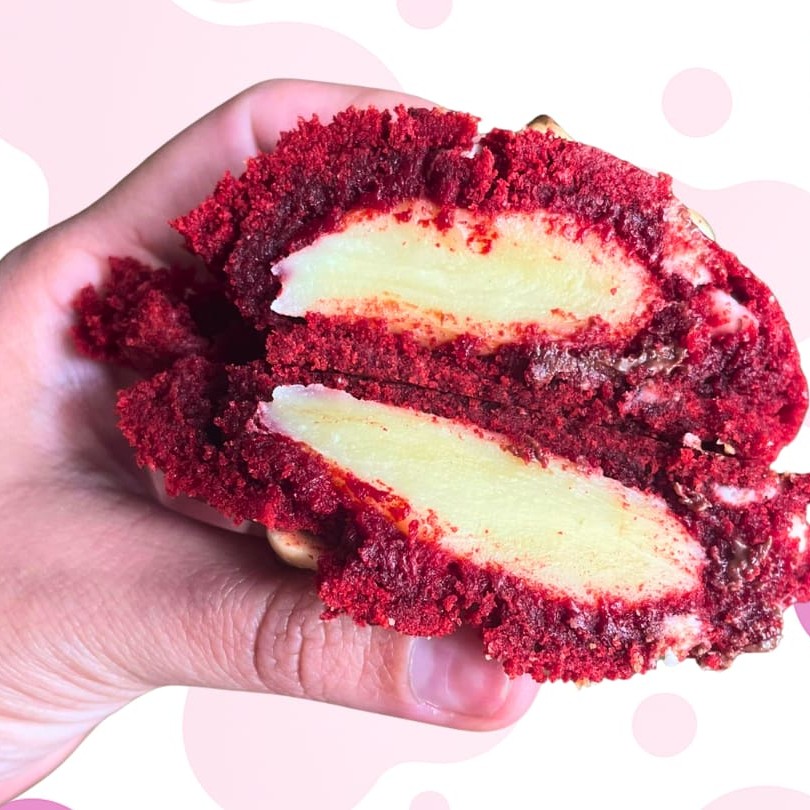 Experimente o nosso cookie Red Velvet: uma explosão de sabor com massa vermelha de cacau 33%, gotas de chocolate branco e um irresistível recheio de brigadeiro de leite Ninho.