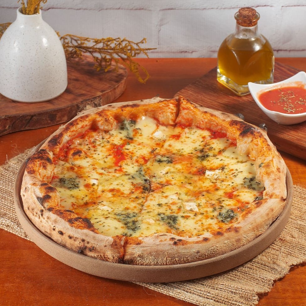 Pizza de longa fermentação com molho de tomate pelatti, muçarela, gorgonzola, parmesão, brie, fio de azeite e orégano.  Tamanho médio: 28 cm
