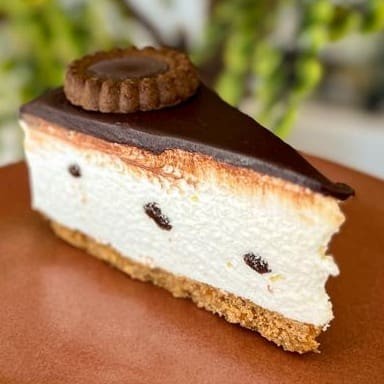 Deliciosa fatia holandesa com casquinha de biscoito, creme de base de leite condensado e chocolate branco e cobertura de ganache meio amargo e finalizado com biscoito de leite maltado aprox. 170g