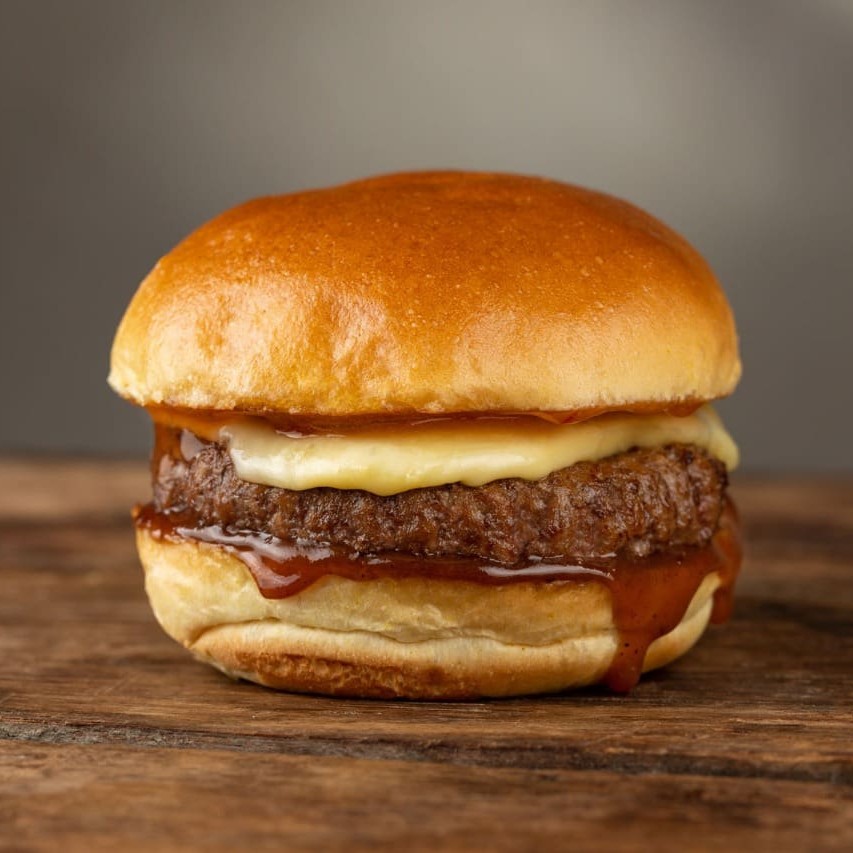 Burger de 150g de pernil suíno, queijo meia cura, geleia de abacaxi com pimenta biquinho e barbecue de pimenta biquinho no pão brioche.