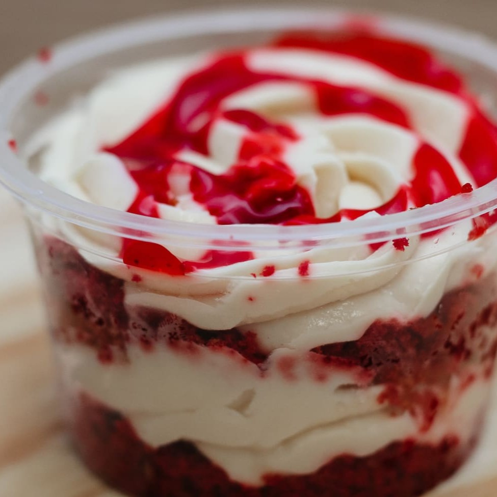 Massa de chocolate, recheio de mousse de chocolate branco e calda de frutas vermelhas. Pote de 250ml.