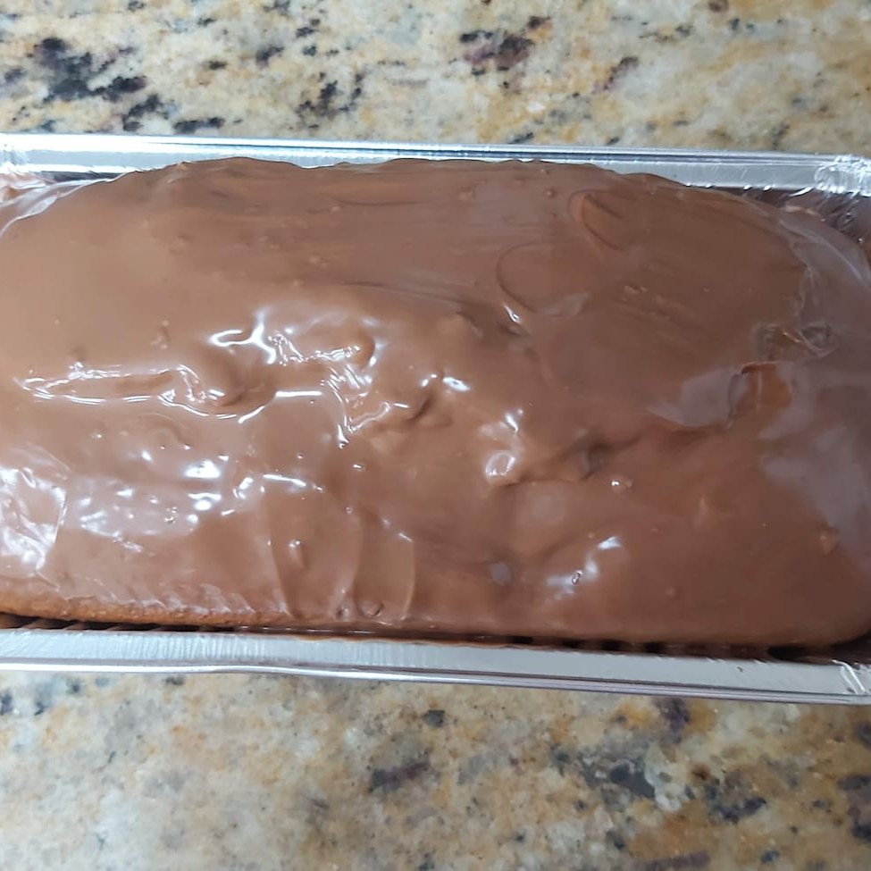 Este Bolo Inglês de Cenoura e Chocolate é assado delicadamente em uma forma de alumínio, especificamente no formato clássico de bolo inglês, pesando aproximadamente 380 gramas ( Média). A inigualável e irresistível combinação do sabor suave do bolo de cenoura, harmoniosamente complementado com uma generosa e deliciosa cobertura de chocolate ao leite em barra derretido, torna este bolo uma verdadeira tentação.