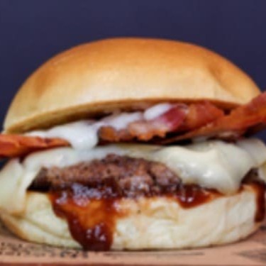 Pão brioche, carne , ovo, fatia de queijo e molho.