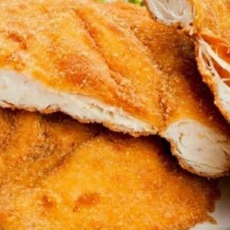 Filé de frango a milanesa com anel de cebola arroz feijão e farofa.