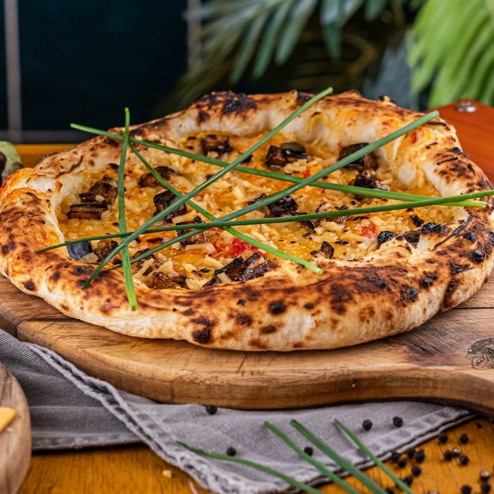 Chevre vegano, mussarela vegana, provolone vegano, molho, beringela, azeite e cebolete.