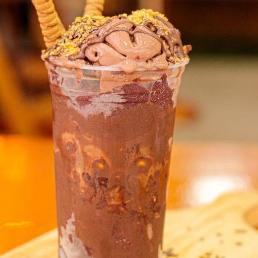 Copo de açaí com o creme de avelã, complementado por pedaços crocantes que elevam a textura e a experiência sensorial.