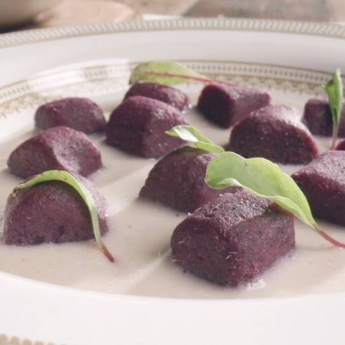 Deliciosos e macios nhoques artesanais feitos com batata doce roxa, servidos com um cremoso molho branco e ervas frescas. Uma opção leve e surpreendente para sua refeição.
