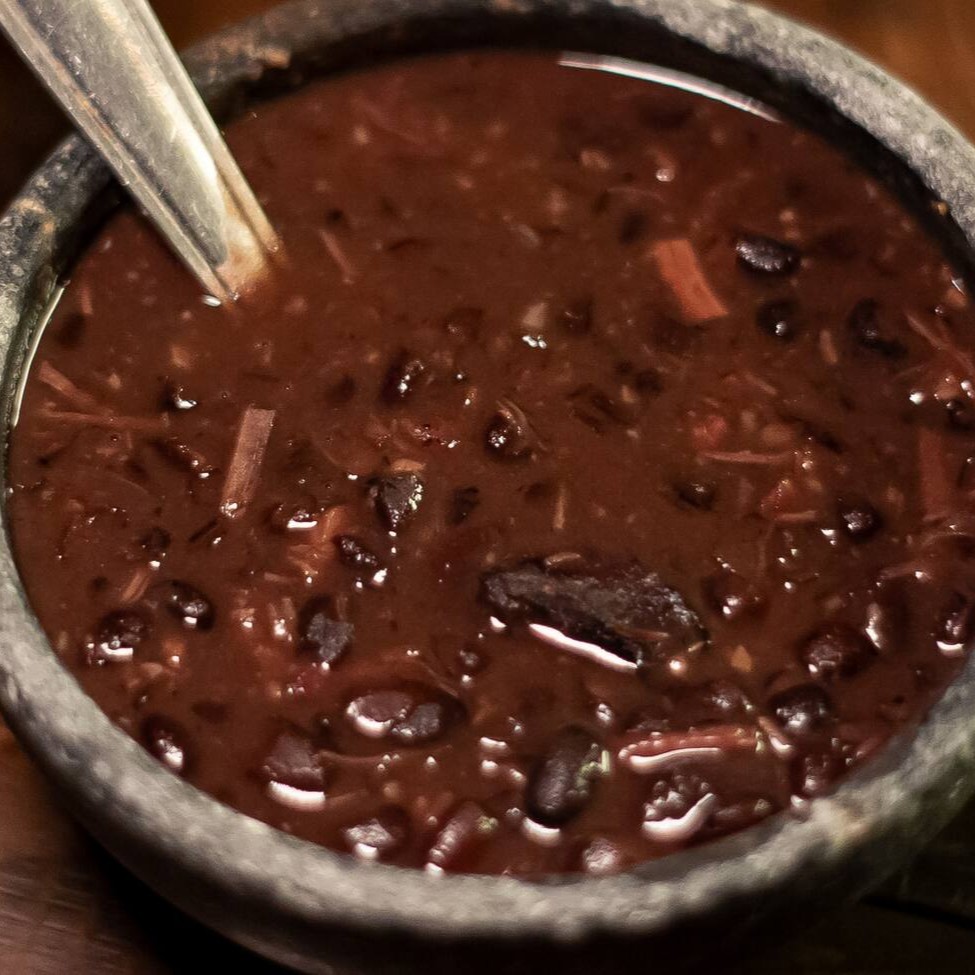 Feijão preto finalizado com cupim, brisket, linguiça e costela, todos defumados na casa. A quantidade é indicada para 2 pessoas já levando em consideração outros dois acompanhamentos.