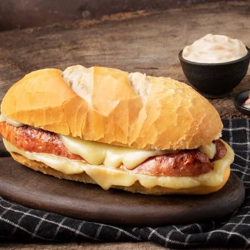 Pão francês com linguiça calabresa e queijo derretido.