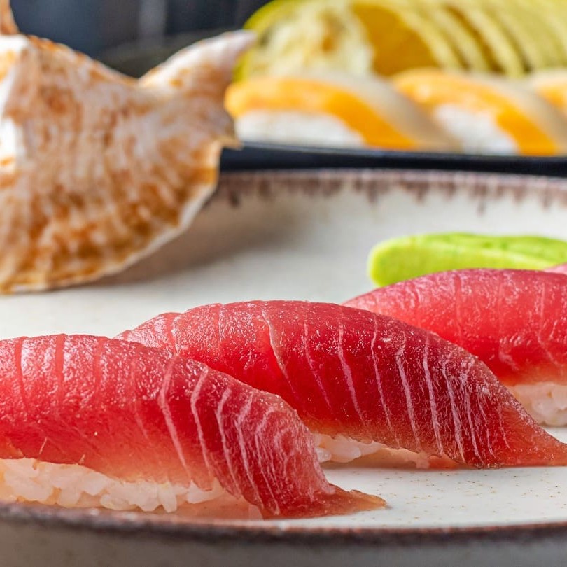 Lâminas de peixe cru - atum, sobre o bolinho de arroz.