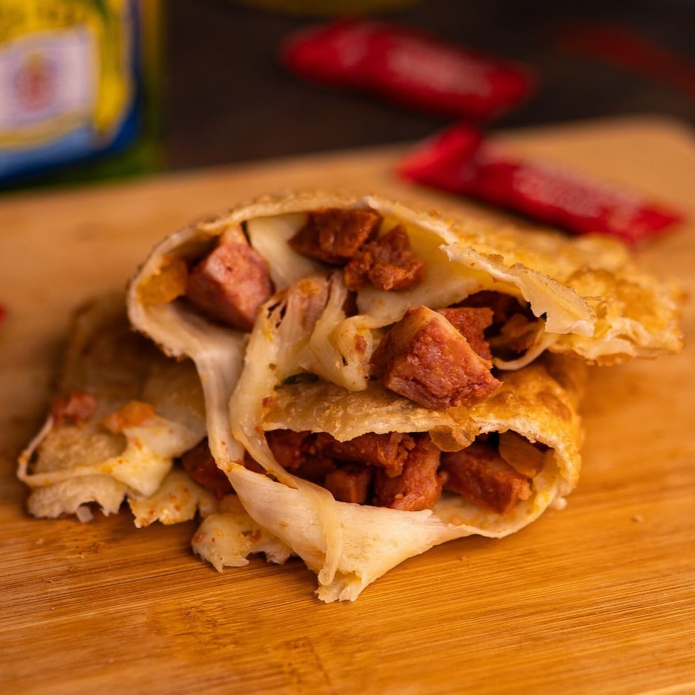 Delicioso pastel de calabresa com cebola e recheado com o queijo mussarela  Pastel com aproximadamente 19cm.
