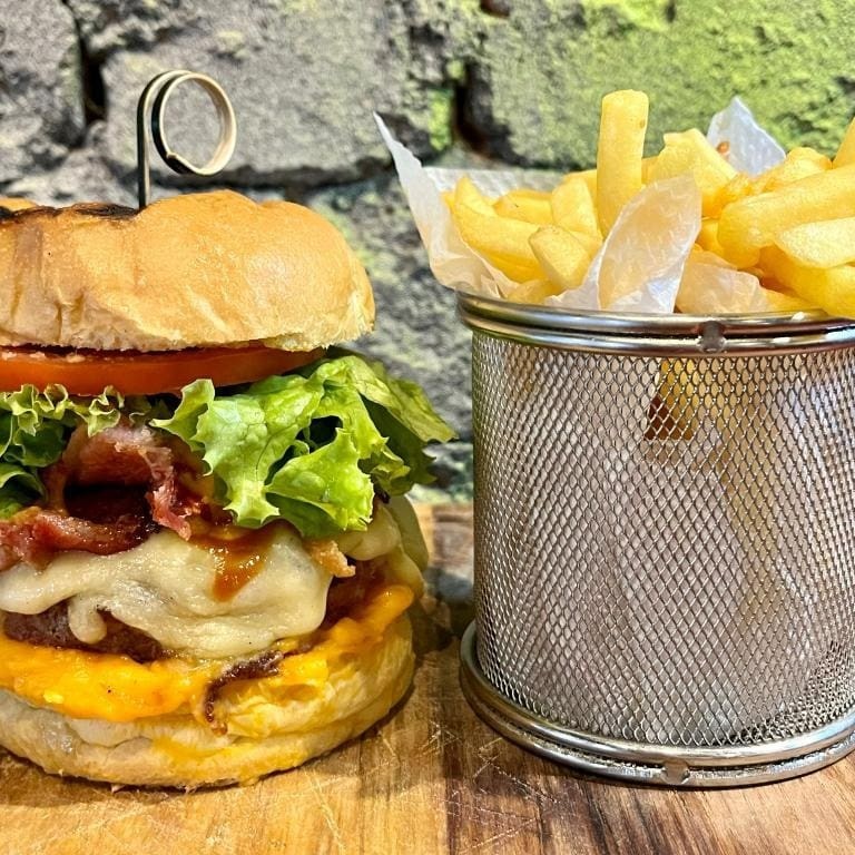 220 gramas de hambúrguer de carne suína, queijo, bacon, barbecue, alface e tomate.