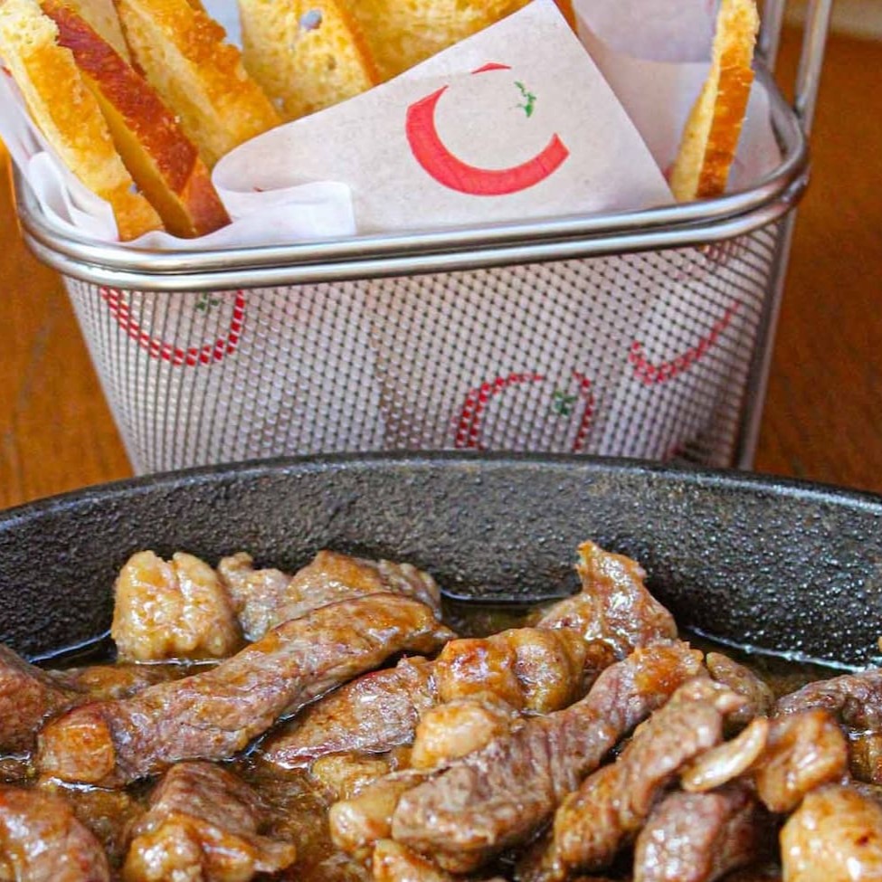 Lascas de filé ao molho madeira e cebola. Acompanha torradas de focaccia.