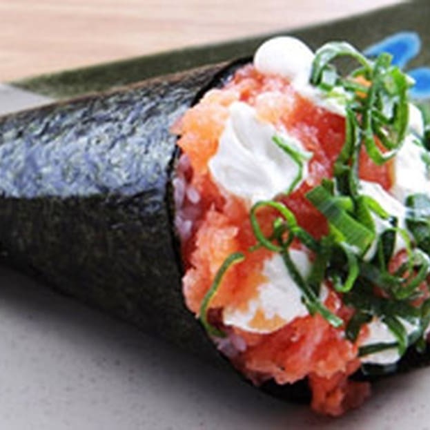 Desfrute de nosso delicioso 'Temaki Philadelphia de Salmão', uma verdadeira joia da culinária japonesa. Este prato encantador é cuidadosamente preenchido com generosas fatias de salmão fresco, garantindo um sabor inigualável. O toque picante da cebolinha, combinado com a suavidade do irresistível cream cheese, cria um equilíbrio perfeito de sabor e textura. Venha se deliciar com essa experiência gastronômica única que o 'Temaki Philadelphia de Salmão' oferece.