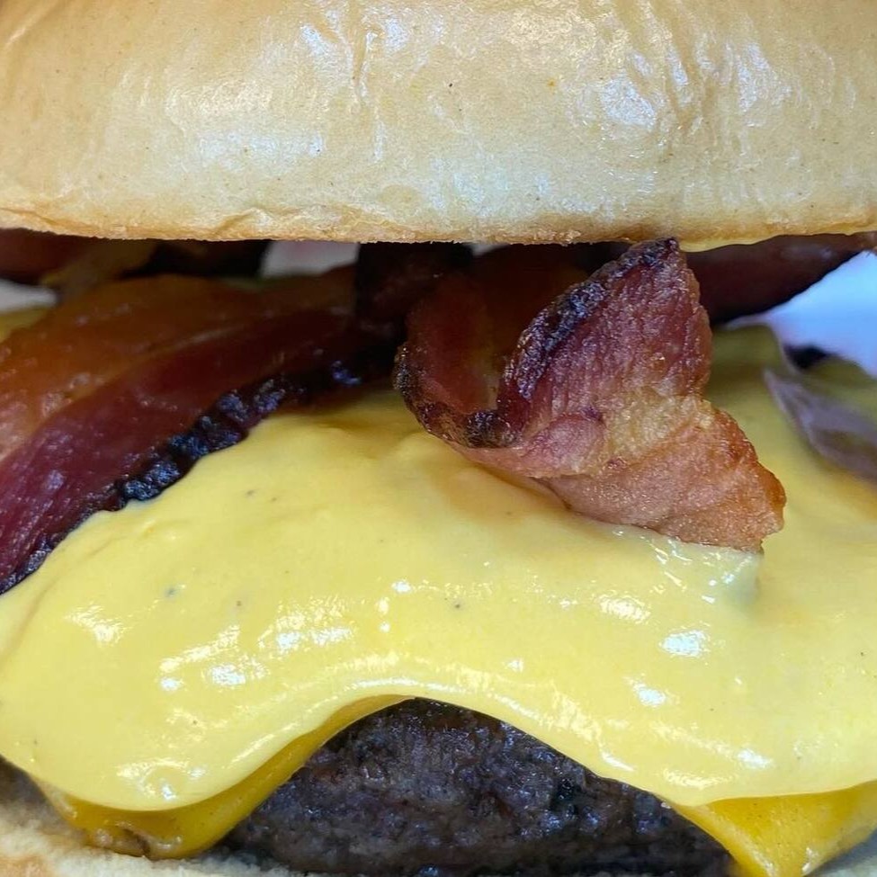 Esse Burger é feito com pão brioche tradicional. Fizemos essa linha pensando em vc que não gosta de pão de alho. Pão brioche, blend feito na churrasqueira, cheddar, creme de cheddar e bacon, tem como dar errado?
