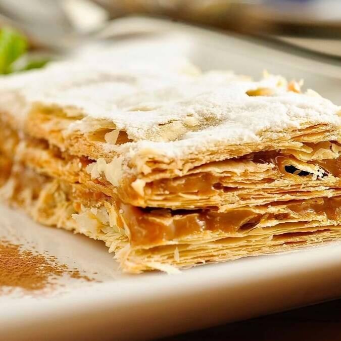 Duas grandes folhas crocantes, creme de ovos Aveiro e açúcar de confeiteiro, folheado de doce de leite.  Foto Ilustrativa