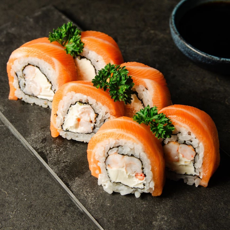 Uramaki de camarão no entorno uma fatia de salmão e um toque de cream cheese.