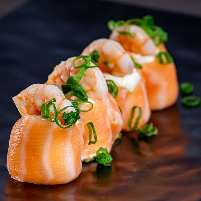 Enrolado de salmão , cream cheese finalizado camarões e cebolinha.