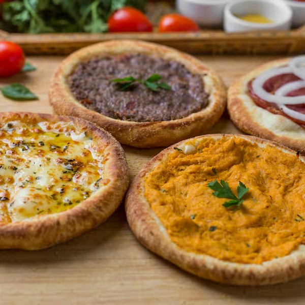 Kit de Esfihas Tradicionais (4 Unidades): 1 de frango temperado, 1 de carne bovina com blend secreto de temperos, 1 de calabresa Sadia e 1 de mussarela com orégano. Grátis cha da casa (natural)