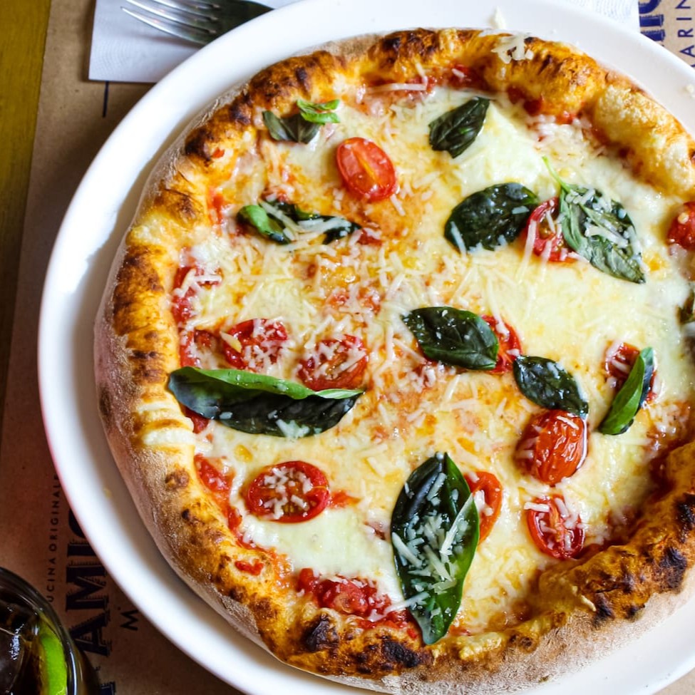 Pizza artesanal feita com tomate pelati, muçarela de búfala cremosa, frescos manjericão e suculentos tomates cereja. Uma combinação perfeita de ingredientes italianos de alta qualidade.