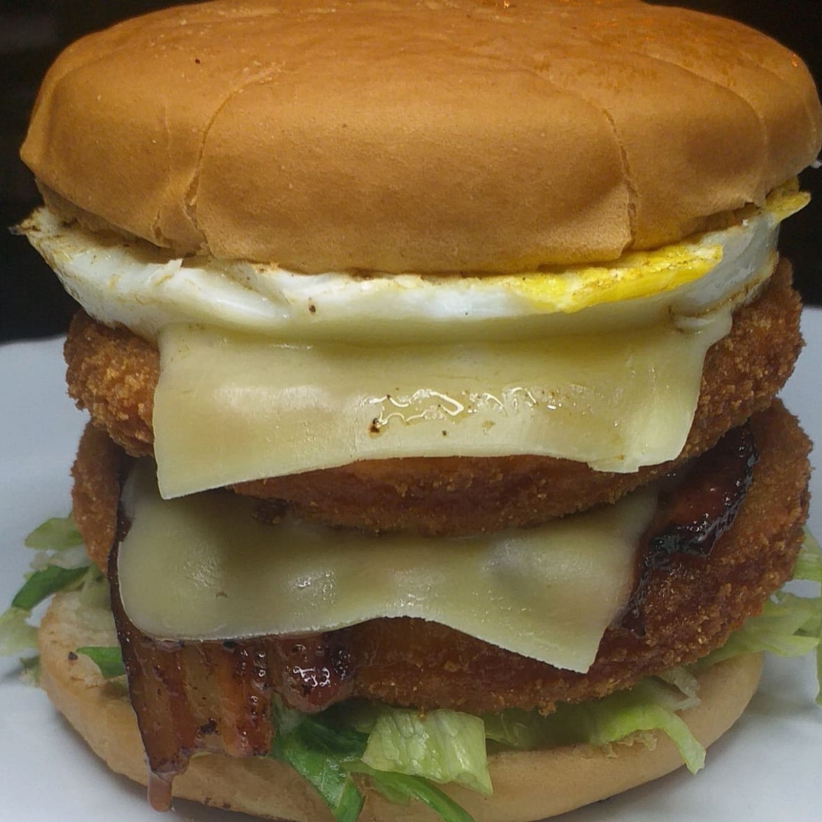 Pão com gergelin 2 Frango empanado, 2 Fatias de Cheddar, Bacon, 1 Ovo, alface americana, tomate e molho especial