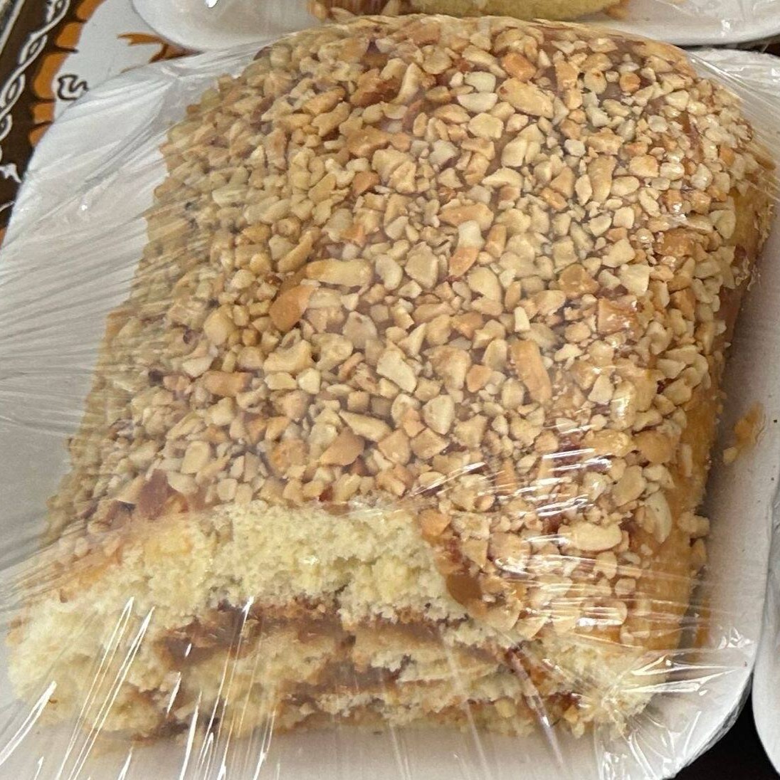 Rocambole recheado com doce de leite e amendoim por cima, tamanho Gg