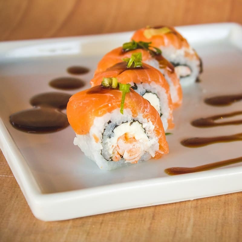Uramaki de camarão com cobertura de salmão.