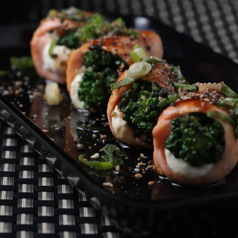 Brócolis e cream cheese envolto em salmão maçaricado.