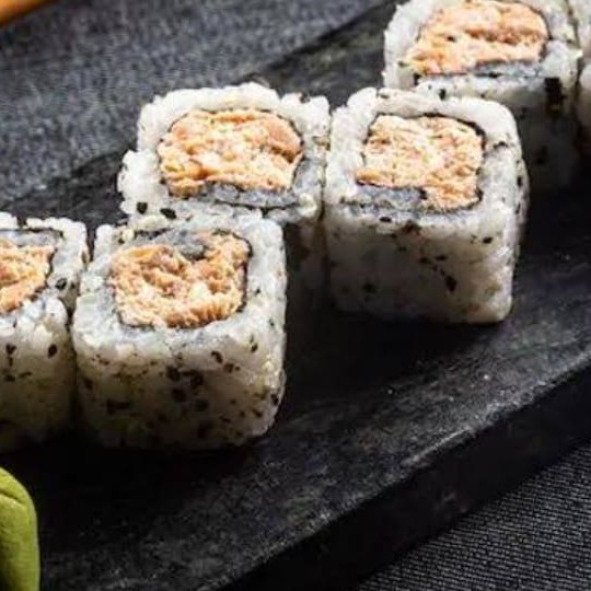 Uramaki de salmão grelhado, enrolado de arroz e gergelim por fora e recheado por dentro de salmão grelhado