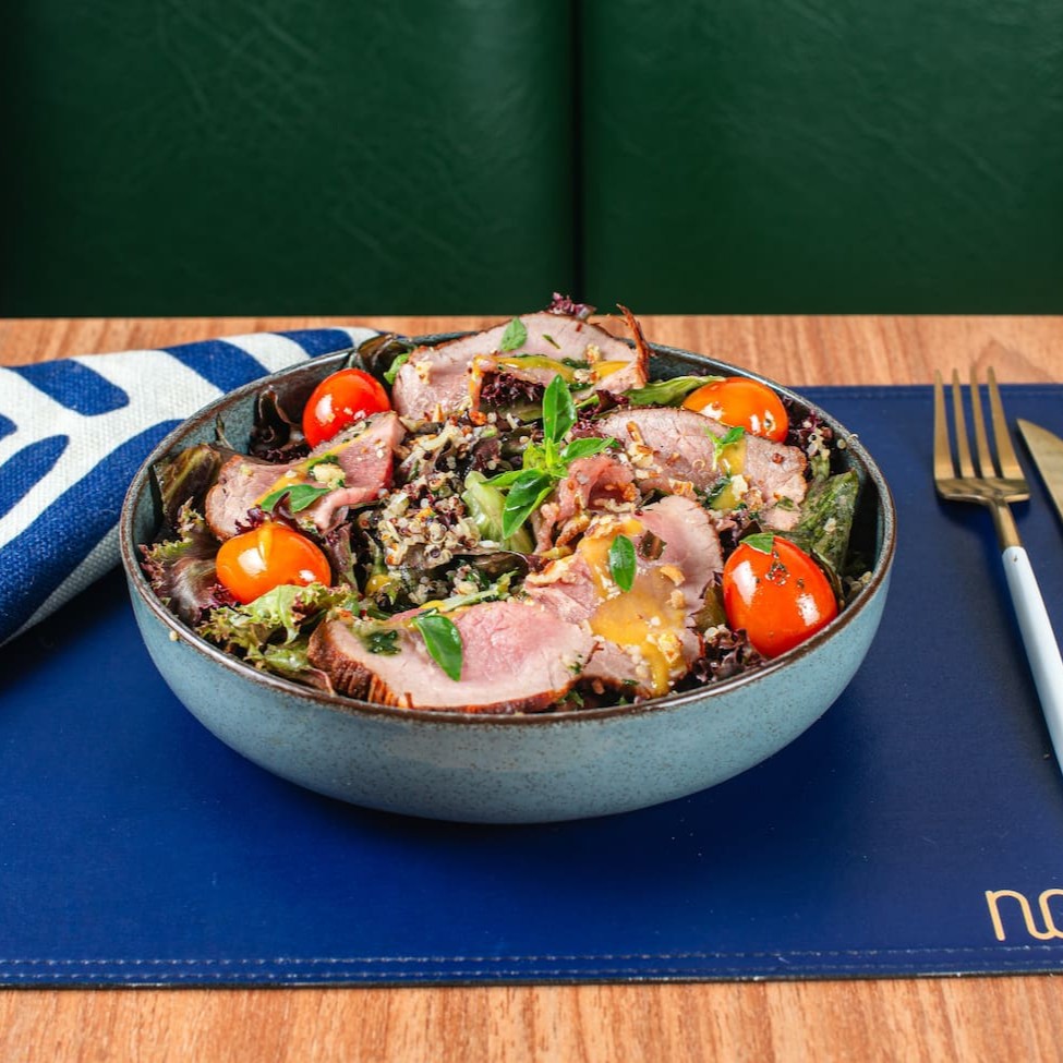 Rosbife fatiado com mix de folhas ao molho de mostarda e mel, queijo crocante, cebola roxa, tomate confit e azeite de manjericão.