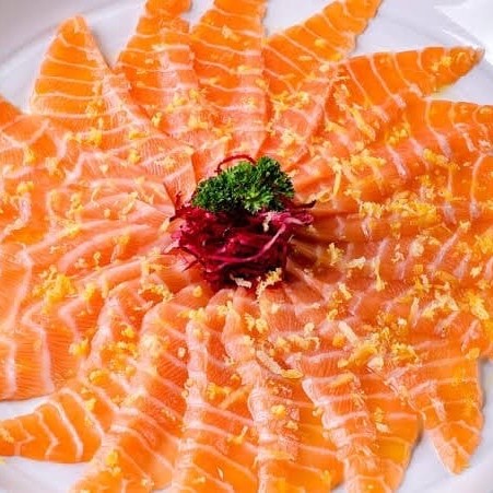 Delicie-se com nosso Carpaccio de Salmão, uma entrada sofisticada e irresistível. São de 12 a 16 lâminas delicadamente finas de salmão fresco, habilidosamente cortadas, realçando a textura suave e o sabor inconfundível deste peixe nobre. Cada fatia é abundantemente regada com nosso tempero exclusivo da casa, uma mistura harmoniosa de Hondashi, Aji-no-moto e azeite de oliva de primeira qualidade. Para um toque extra de sabor e cor, adicionamos cebola roxa finamente fatiada como opcional. Uma combinação perfeita de ingredientes que, juntos, resultam em uma experiência gastronômica única e memorável.
