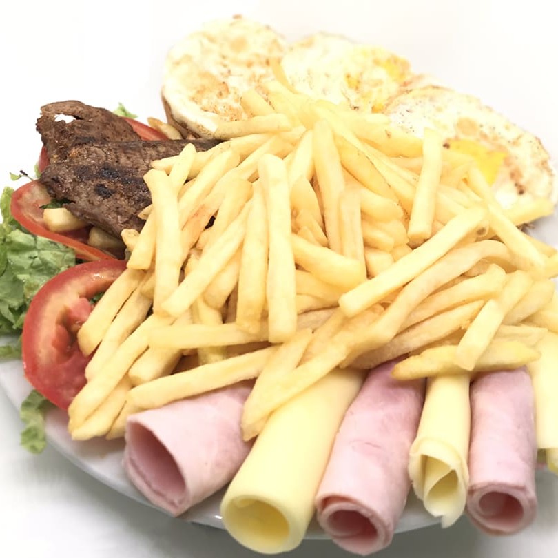 4 pães de forma, 4 ovos fritos, 4 fatias de queijo prato, 4 fatias de presunto, alface, tomate, muita batata-frita, 4 bifes de carne.