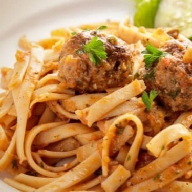 Fettuccine com almôndegas é um prato clássico da culinária italiana que combina massa tipo fettuccine, que são largas e achatadas, com almôndegas suculentas feitas geralmente de carne moída, temperos e, às vezes, queijo. O prato é frequentemente servido com um molho de tomate rico e saboroso, que envolve a massa e as almôndegas, criando uma refeição reconfortante e cheia de sabor. É uma escolha po