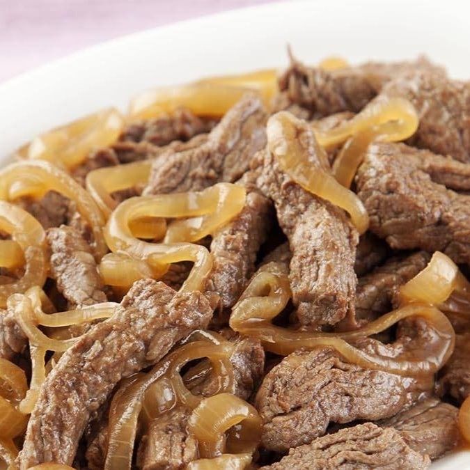 Tiras de filé de alcatra, refogadas na manteiga com cebolas douradas, Uma Delícia. Acompanha Feijão preto, arroz branco, farofa da casa e batata frita. Refeição individual. Servida em uma marmita de 750ml