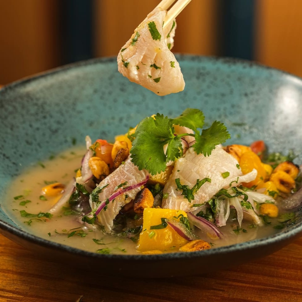 Peixe branco, leite de tigre, manga, cebola roxa, coentro, pimenta e milho crocante.