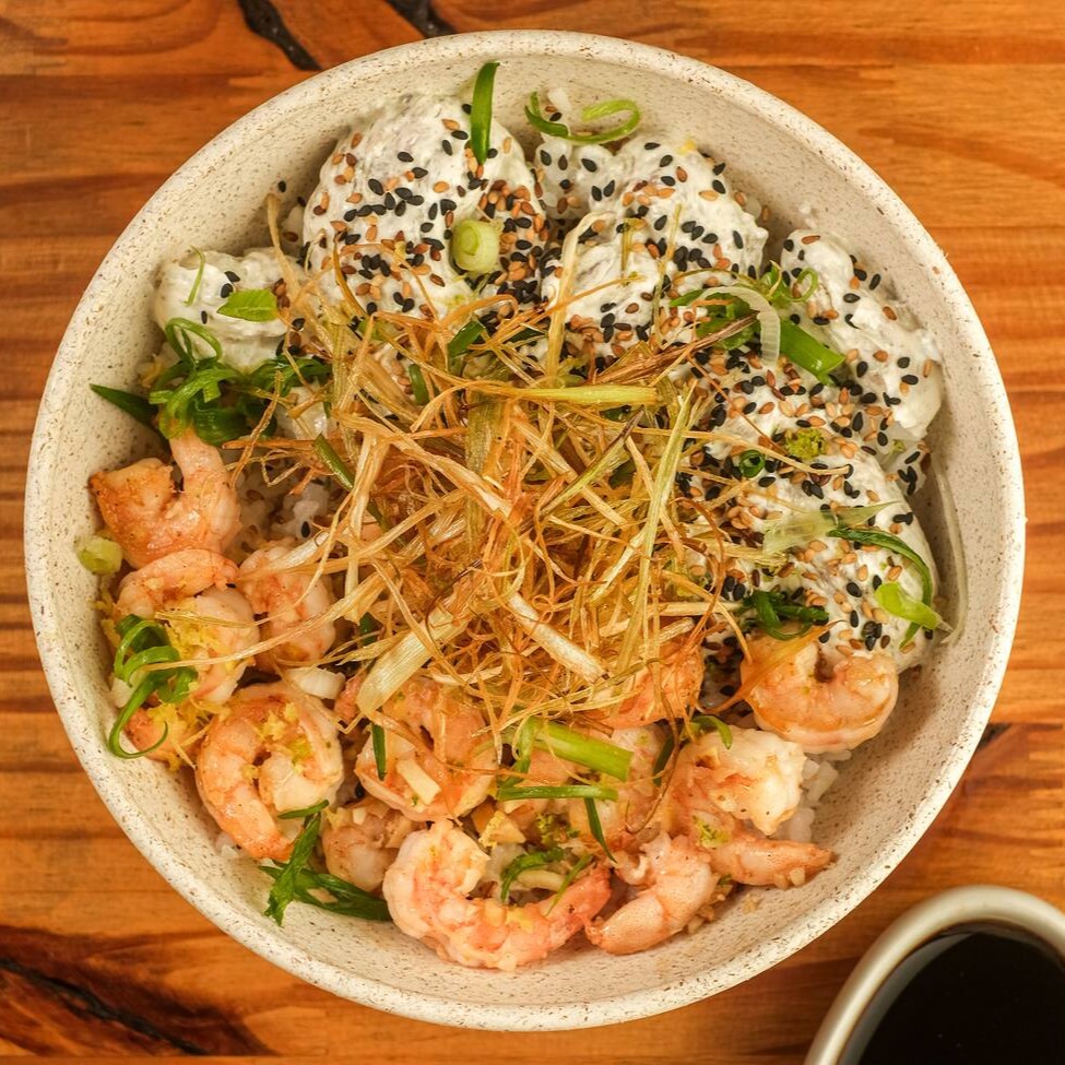 Base de arroz gohan, camarão grelhado com toque de alho, Koa cream cheese (com nori), gergelim, finalizado com raspa de limão siciliano, cebolinha e palha de alho poró. Acompanha Koa molho havaiano.