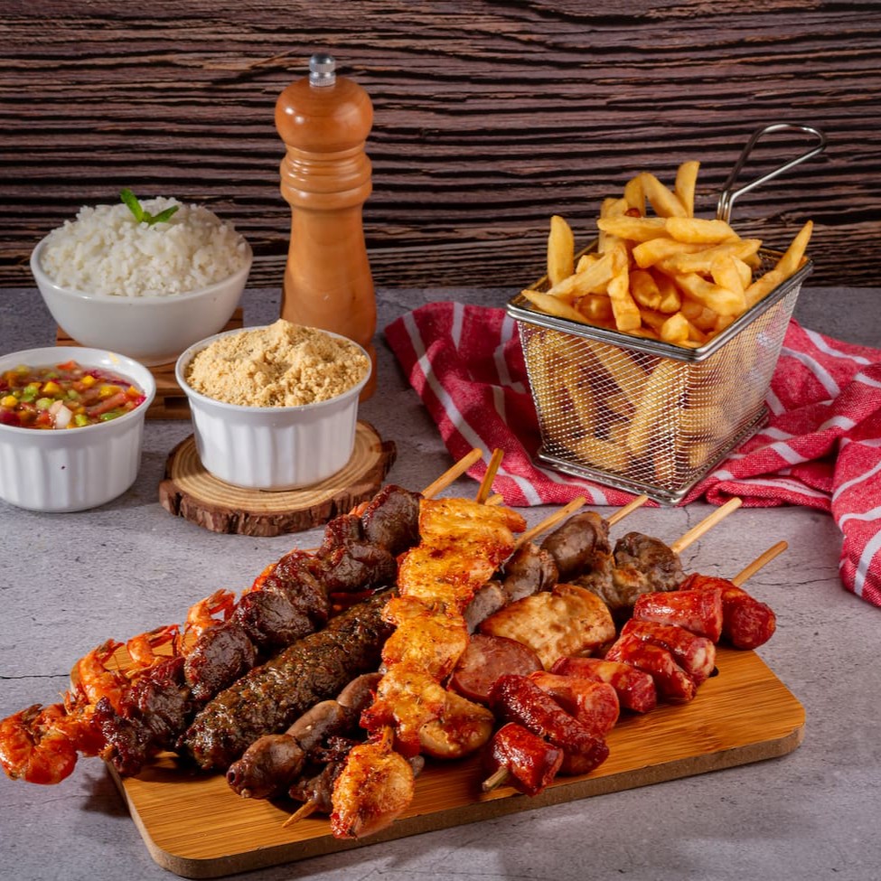 Aproveite o Combo Mix, uma combinação irresistível para satisfazer sua fome! São 5 espetos deliciosos, preparados com todo o carinho e sabor que você conhece. Acompanha uma porção generosa de batata frita (450 gramas), crocante e cheia de sabor. Se desejar, adicione uma porção de farofa para um toque especial. Para completar sua refeição, desfrute de um refrigerante de dois litros bem gelado, perf