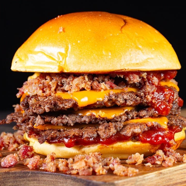 O nosso smash triplo bacon combina três Blends de 80g cada smashado + bastante queijo cheddar, farofa de bacon crocante e pão brioche selado na manteiga.