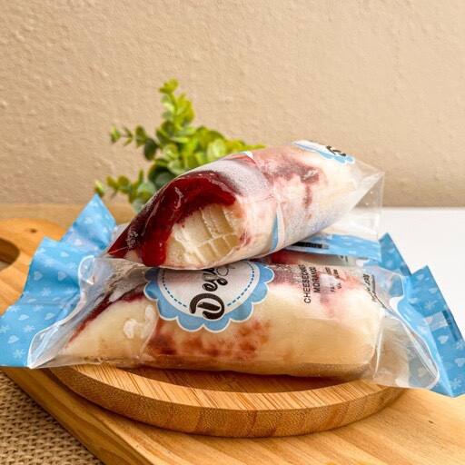 Experimente o prazer refrescante e sofisticado de um sacolé de Cheesecake com cream cheese 100% original e geléia de morango artesanal.