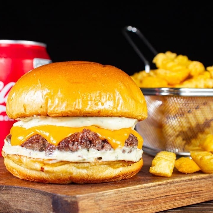 Delicioso Blend de 120g, com fatias de queijo cheddar + a nossa classíca e saborosa maionese verde da casa no pão brioche selado na manteiga.