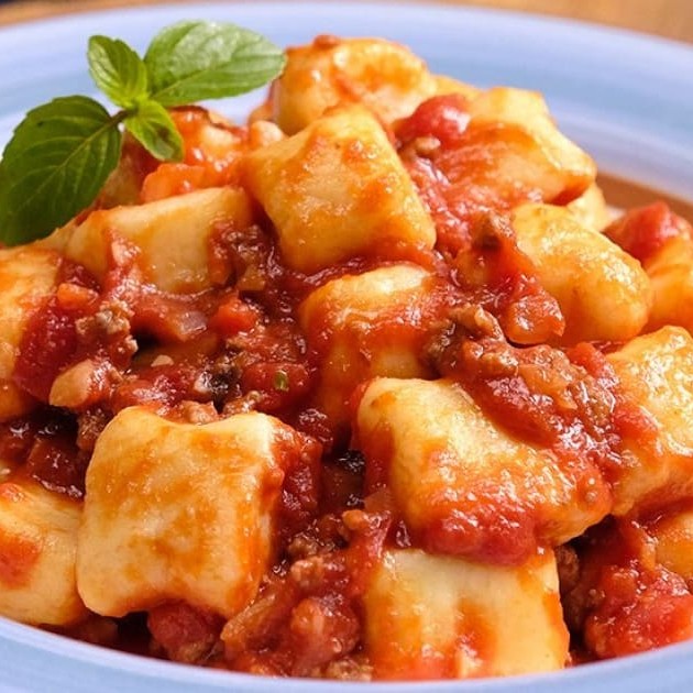 Desfrute de uma explosão de sabores com o nosso Nhoque ao Molho Secreto à Moda da Casa! Este prato imperdível apresenta um molho à Bolonhesa enriquecido com a textura irresistível da calabresa picada e o sabor defumado do bacon picado. E para elevar a experiência a um nível superior, acrescentamos o toque especial do catupiri e o toque clássico do parmesão derretido, proporcionando uma harmonia de