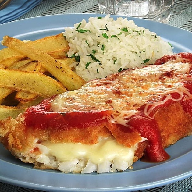 Filé de panga empanado na panko coberto por molho de tomate e aquele queijo mussarela derretendo...acompanhado de arroz, feijão ou pirão e mais um complemento.