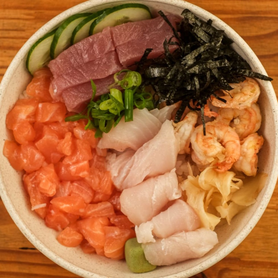 Base de arroz gohan, cubos de salmão, sashimi de atum, sashimi de peixe branco, camarão grelhado, pepino japonês, alga nori, wasabi, gari (gengibre em conserva) e cebolinha. Acompanha Koa molho havaiano.