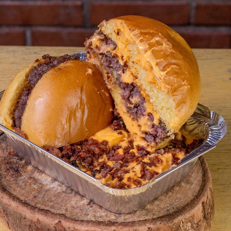 Pao brioche, Blend Angus 160gr, Maionese, Queijo Cheddar fatia, banhados numa piscininha com muito Cheddar e Farofa de Bacon