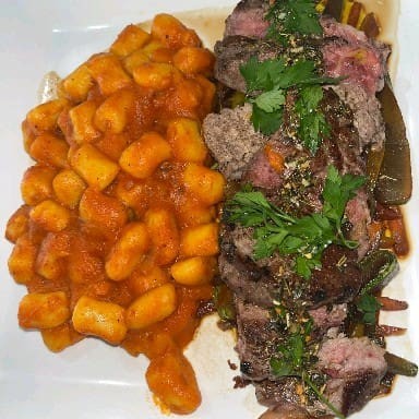 Delicioso, filé mignon grelhado com uma caponata de legumes e inhoque pomodoro finalizado com o molho chimichurre