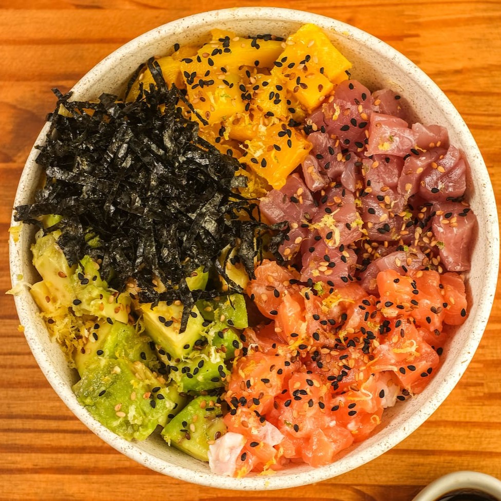 Base de arroz gohan, cubos de salmão e atum, manga, abacate finalizado com raspa de limão siciliano, gergelim e alga nori. Acompanha Koa molho havaiano e Koa molho teriyaki.
