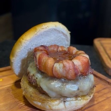Pão de bacon, Blend bovino 150 gr, mussarela, anel de cebola envolto com bacon e molho barbecue..