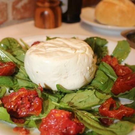 Com rúcula, tomate seco e molho pesto.